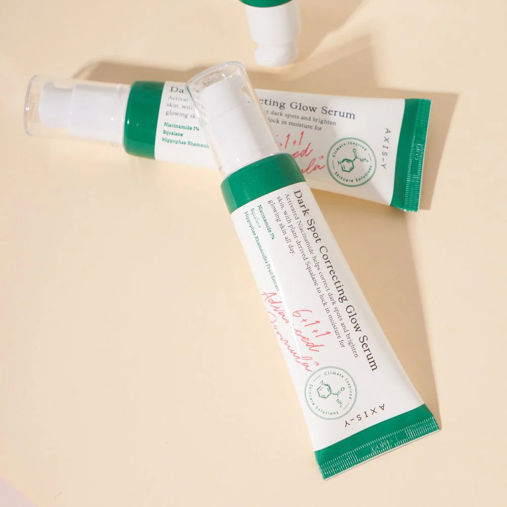 AXIS-Y Dark Spot Correcting Glow Serum with niacinamide and squalane, shown in multiple tubes on a beige background, Korean skincare for hyperpigmentation and brightening.
