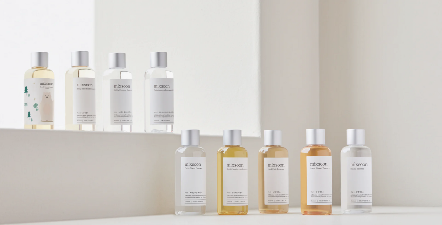 Mixsoon essence collection displayed on white podiums, featuring best-selling Korean skincare treatments like Beta-Glucan, Galactomyces, and Heartleaf. Available at The Koko Collection.