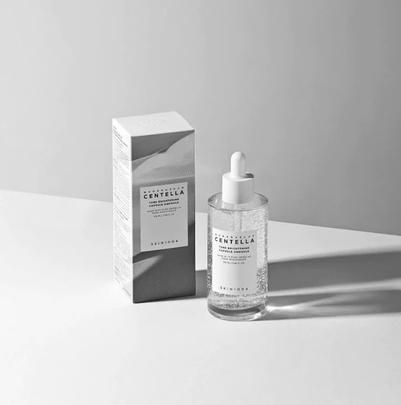 Monochrome product and packaging photo of SKIN1004 brightening ampoule with dropper bottle and shadow play