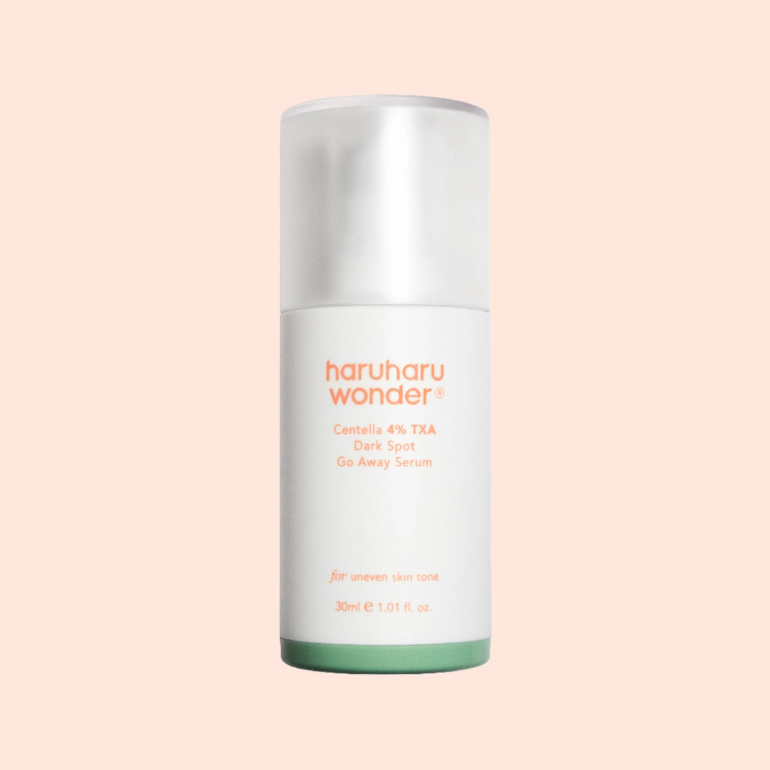 Haruharu Wonder Centella 4% TXA Dark Spot Go Away Serum bottle on a soft peach background, targeting uneven skin tone and dark spots with brightening ingredients.