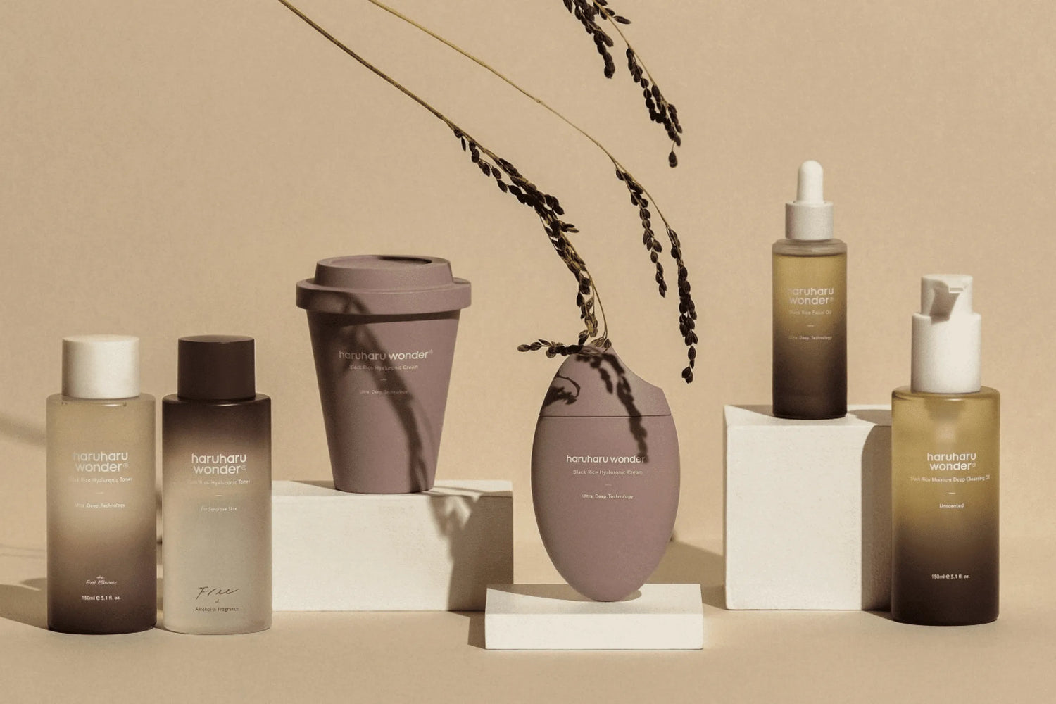 Elegant flatlay of Haruharu Wonder skincare products including toners, oils, and creams, styled with minimalist earthy tones. Shop K-beauty at The Koko Collection.