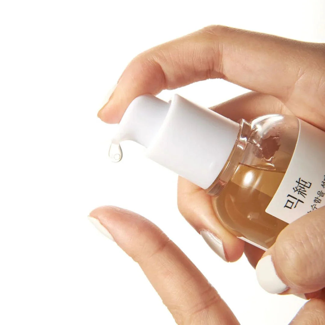 Mixsoon Bean Essence being dispensed onto fingertips, highlighting its lightweight, hydrating texture for glowing skin.