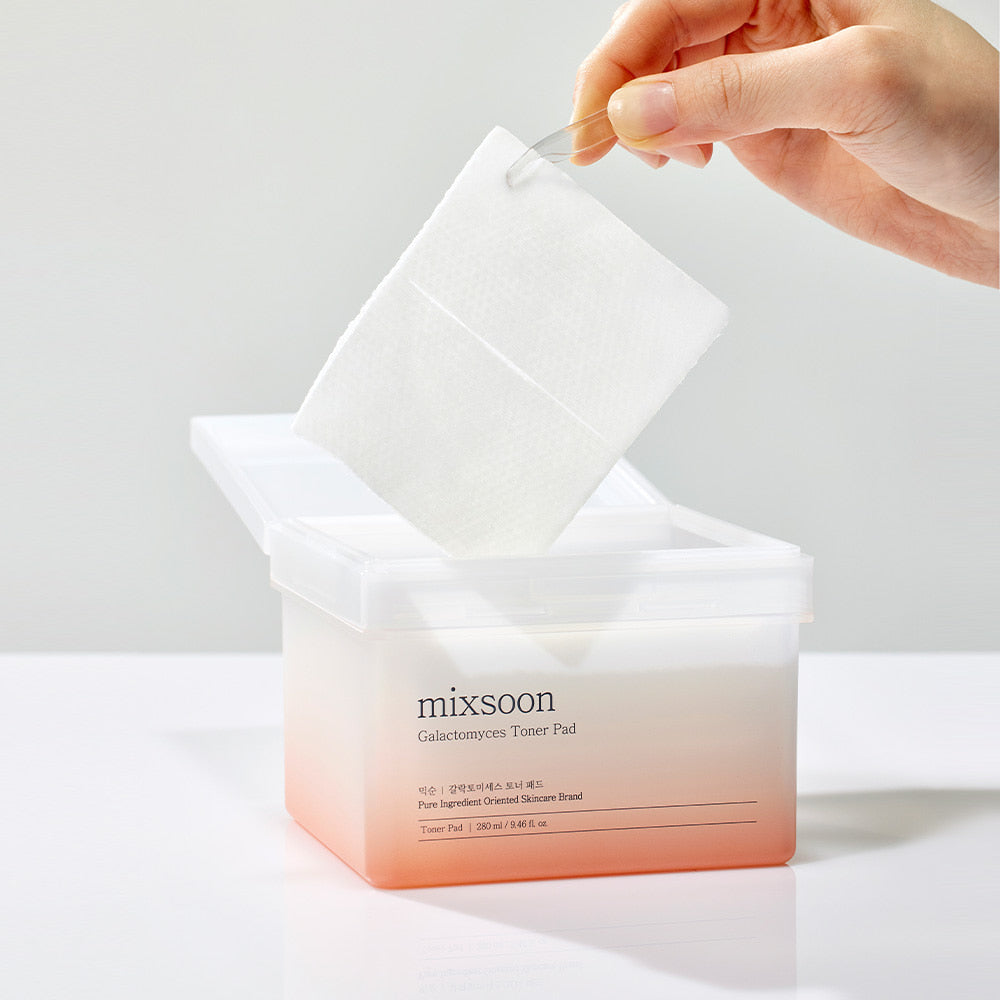 Mixsoon Galactomyces Toner Pad being lifted with tweezers from its container, showcasing its hydrating and brightening skincare benefits.