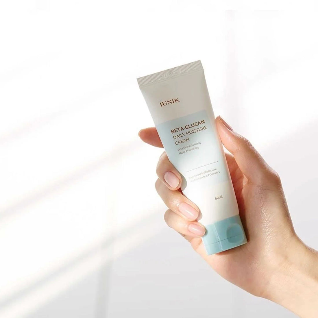 Hand holding iUNIK Beta-Glucan Daily Moisture Cream – lightweight Korean moisturizer for sensitive and dry skin.
