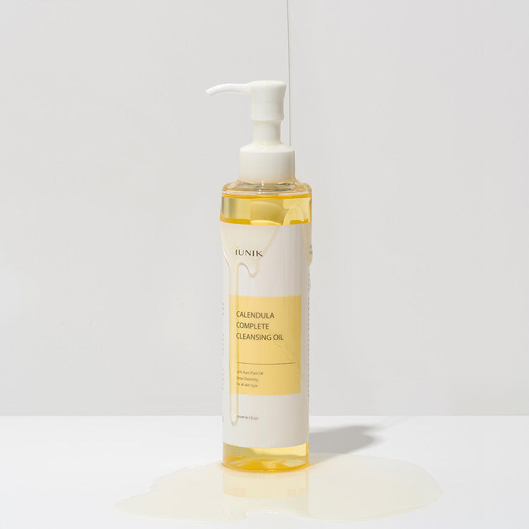 iUNIK Calendula Complete Cleansing Oil bottle with product spilled on surface – gentle Korean oil cleanser for sensitive and all skin types